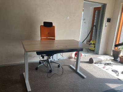 Kancelářský stůl s elektricky nastavitelnou výškou a s židlí.